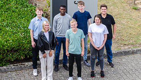 Herzlich Willkommen im nolteteam! Sechs junge Leute vor einem Firmenschild