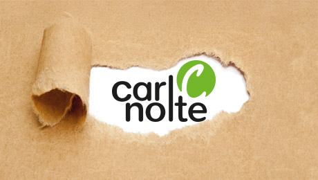 Packpapier, aus dem ein Streifen in der Mitte herausgerissen wurde. Darunter ist das Logo der Carl Nolte Technik zu sehen