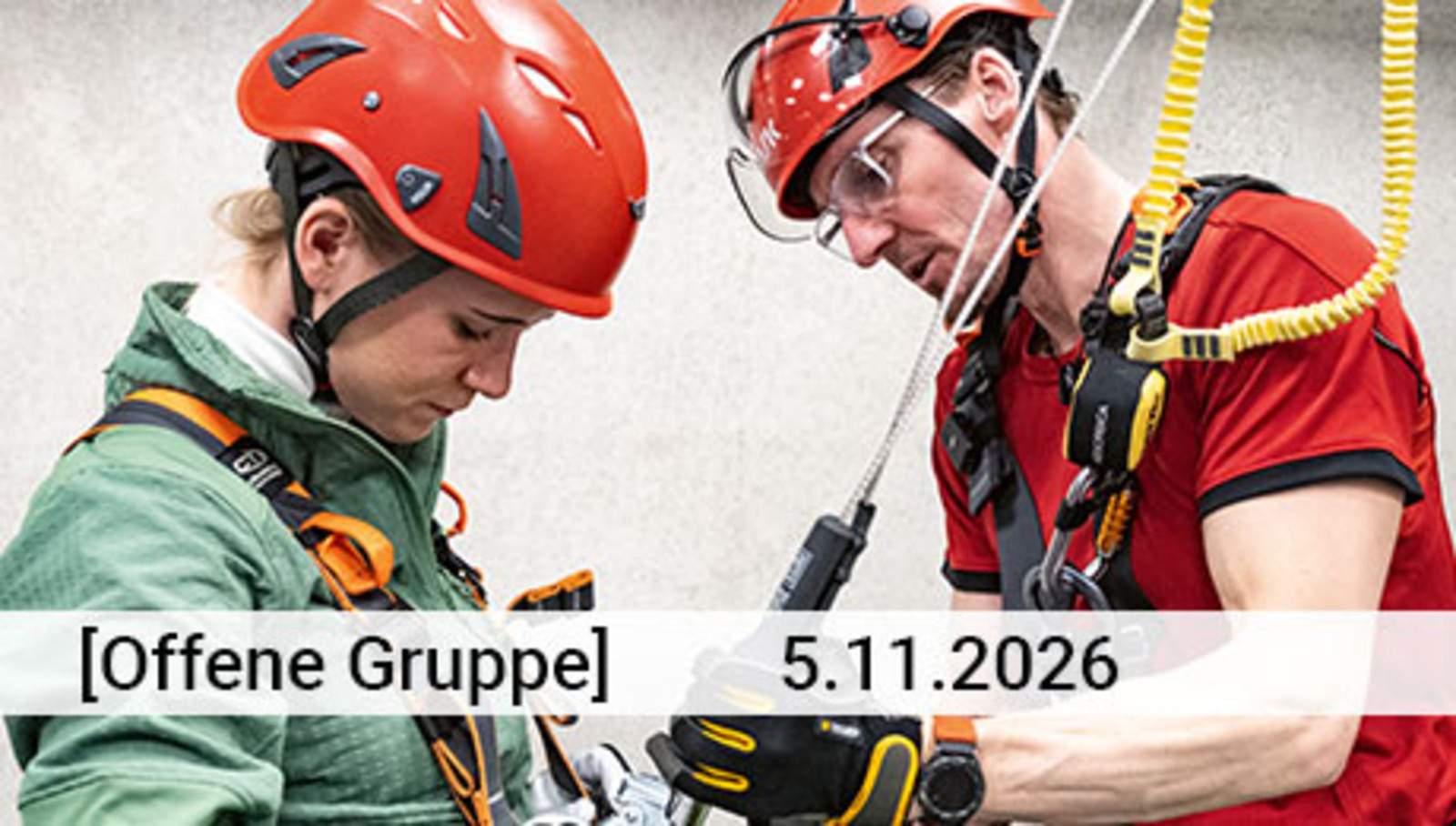 Zwei Personen mit roten Sicherheitshelmen und Abstursicherungsgurten; der Mann rechts unterstützt die Frau (links) beim Einhaken in die Sicherung. Darüber Text: Offene Gruppe und eine Datumsangabe
