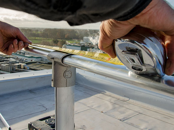 Geländermontage einer Dachabsicherung: Ausmessen per Maßband